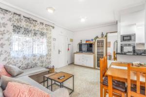 a living room with a couch and a table at Ground floor apartment with terrace and pool in La Mata