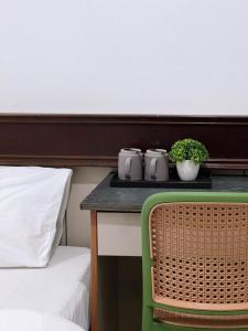 a room with a table with two beds and a green chair at Pillows Plus City Top in Cheras