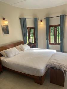 a bedroom with two large beds with blue curtains at Sarangu VIlla in Akuressa