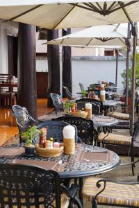 a row of tables with chairs and umbrellas at Treasure Heritage Hotel in Luang Prabang
