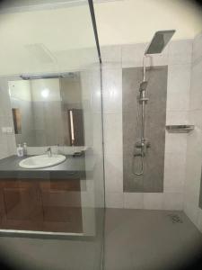 a bathroom with a sink and a shower with a mirror at Sarangu VIlla in Akuressa