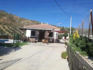 ein Haus mit einer Terrasse und einem Zaun in der Unterkunft Caminito Del Rey Valley House in Valle de Abdalagís