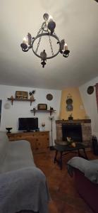 ein Wohnzimmer mit einem Kronleuchter, der von der Decke hängt in der Unterkunft Caminito Del Rey Valley House in Valle de Abdalagís