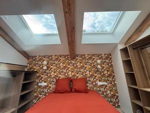 a bedroom with two windows and a bed with red sheets at La Master Grange De Queyran in La Palud sur Verdon
