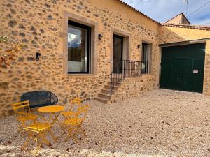 a table and chairs in front of a house at La Master Grange De Queyran in La Palud sur Verdon