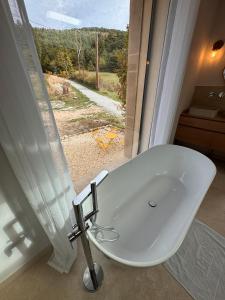 a white bath tub in a bathroom with a window at La Master Grange De Queyran in La Palud sur Verdon +15 photos