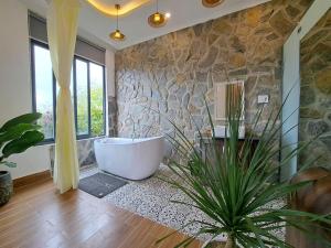 a bathroom with a tub and a plant in it at Khu vườn của Nàng Đà Lạt - Le Jarden De Nàng in Da Lat