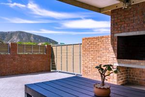 a balcony with a potted plant on a brick wall at S Haven Luxury Self Catering Apartment in Franskraalstrand