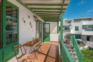 a balcony of a house with a table and chairs at El Gin in Playa Blanca