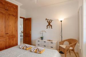 a bedroom with a bed and a chair and a table at El Gin in Playa Blanca