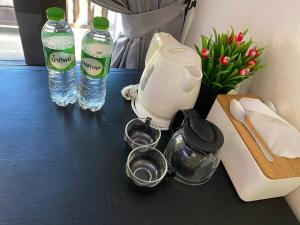a counter with two bottles of water and a blender at Sea view room in Nathon Bay