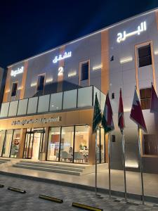 a building with flags in front of it at night at البرج للشقق المخدومة 2 in Al Nairyah