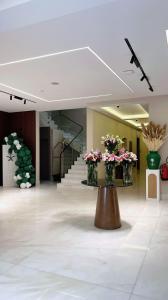 a lobby with a table with flowers on it at البرج للشقق المخدومة 2 in Al Nairyah