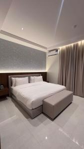 a bedroom with a large white bed and a window at البرج للشقق المخدومة 2 in Al Nairyah