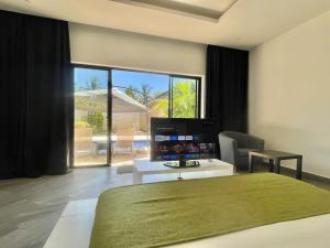 a bedroom with a bed and a view of a patio at Grand Amber Villa in Diani Beach