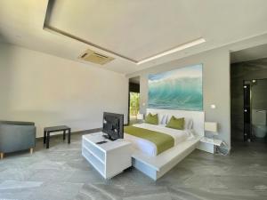 a bedroom with a bed and a television in it at Grand Amber Villa in Diani Beach
