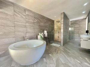 a large bathroom with a large tub and a sink at Grand Amber Villa in Diani Beach