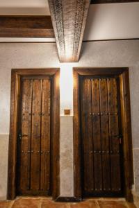 two wooden doors in a room with a ceiling at La Cachava in Castrojeriz