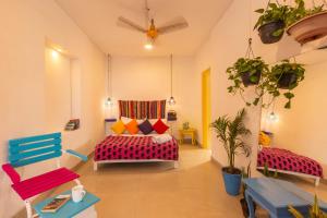 a living room with colorful chairs and a bed at goSTOPS Lite Jaipur in Jaipur