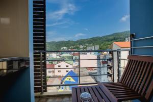 Un balcón con un banco y vista a una ciudad. en Aim House, en Patong Beach