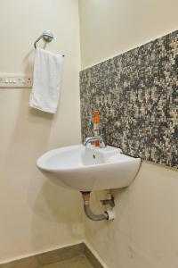 Immanuel Homestay, Kalathipady, Kottayam, Flat C في كوتايم: بالوعة بيضاء في الحمام بجدار بلاط