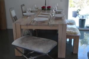 een houten tafel met stoelen en wijnglazen erop bij Haus Speckgürtel Hamburg in Henstedt-Ulzburg +2 foto's