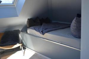 een bed in een kleine kamer met een stoel bij Haus Speckgürtel Hamburg in Henstedt-Ulzburg