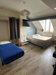 a bedroom with a bed and a flat screen tv at Appartement Peronne Centre in Péronne