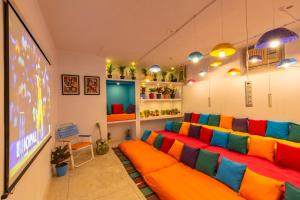 a living room with a colorful couch in front of a tv at goSTOPS Lite Jaipur in Jaipur
