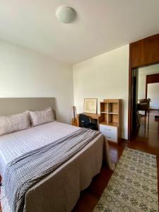 Un dormitorio con una cama, una mesa y un espejo. en QUARTO ASSEMBLEIA Lourdes, en Belo Horizonte