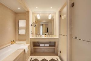 a bathroom with a tub and a sink at Hôtel Métropole Monte-Carlo - Spa Guerlain in Monte Carlo