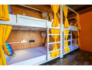 a room with two bunk beds with yellow curtains at goSTOPS Pondicherry Near Auroville in Auroville