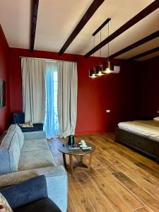 a living room with red walls and a couch and a table at Javakhishvilebis Marani in Akhalsopʼeli