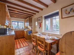 Syderstoneにある3 Bed in Syderstone KT083の木製のテーブルと椅子が置かれたキッチン