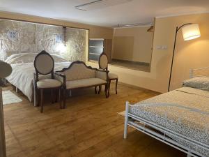 ein Schlafzimmer mit 2 Stühlen, einem Bett und einem Spiegel in der Unterkunft Loft al centro in Avola