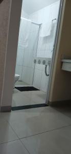 a bathroom with a shower with a toilet and a sink at Chácara e Pousada Aeroporto in Andradina +16 photos
