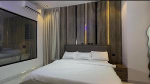 a bedroom with a white bed and a large window at Danjo Shortlets in Aja