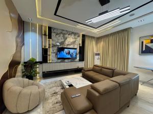a living room with a couch and a flat screen tv at Danjo Shortlets in Aja