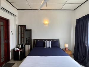 a bedroom with a blue bed in a room at RIVINSON Negombo in Negombo