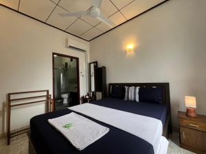 a bedroom with a bed with a towel on it at RIVINSON Negombo in Negombo