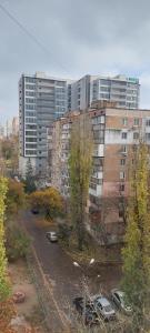 a large building with cars parked in a parking lot at Центр 3 слободская АТБ in Mykolaiv
