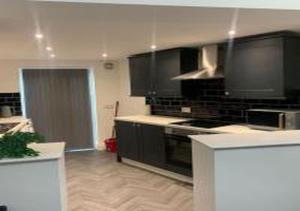 eine Küche mit schwarzen Schränken und einem Herd in der Unterkunft A&A Luxury Stay Tunstall in Sunderland + 21 Fotos