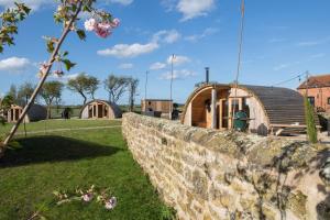EbberstonにあるThe Hygge Out - Glamping Site in North Yorkshireの木造住宅の隣にある石造りの擁壁