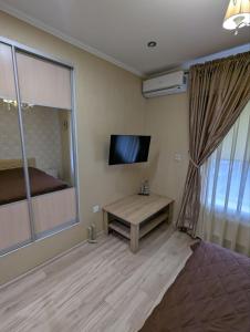 a room with a bed and a table and a television at Villa Maria in Novoarkhanhel's'k