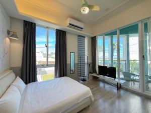 花蓮市にあるBlue Ocean 微藍海岸 海景電梯旅宿 - 近東大門夜市のベッドと薄型テレビのある寝室 +42枚の写真