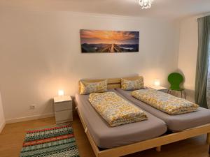 a bedroom with two beds and a painting on the wall at Ferienwohnung Kity mit Terrasse und Bergblick in Grainau