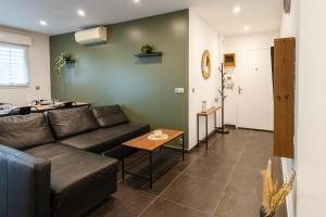 ein Wohnzimmer mit Sofa und Tisch in der Unterkunft Cosy de la Pointe Rouge - Terrasse - Port plage et commerces in Marseille