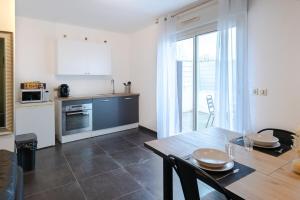 eine Küche und ein Esszimmer mit einem Tisch und einem Esszimmer gmaxwell gmaxwell in der Unterkunft Cosy de la Pointe Rouge - Terrasse - Port plage et commerces in Marseille