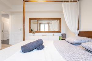 Schlafzimmer mit einem großen weißen Bett und einem Spiegel in der Unterkunft Cosy de la Pointe Rouge - Terrasse - Port plage et commerces in Marseille