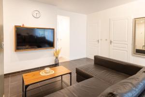 ein Wohnzimmer mit Sofa und Tisch in der Unterkunft Cosy de la Pointe Rouge - Terrasse - Port plage et commerces in Marseille + 10 Fotos